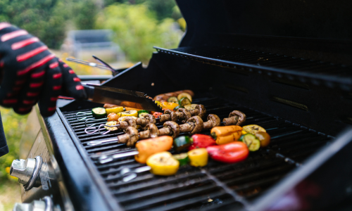 A close-up of vegetables on a grill being cooked.